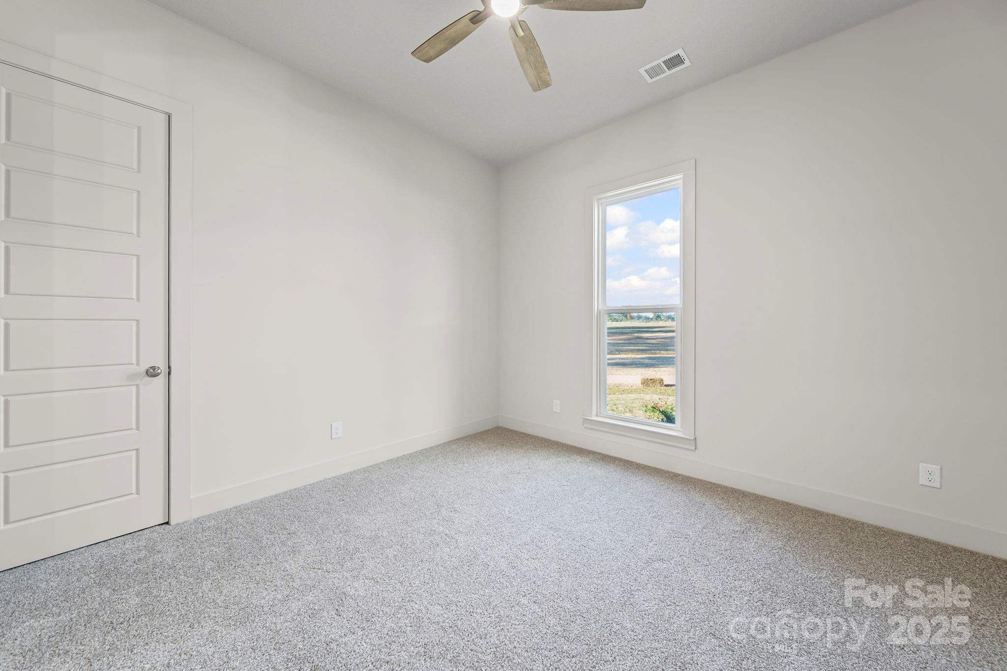 2417 Plyler Mill Road Monroe, NC 28112 - Photo 19 of 34 an empty room with a window and chandelier fan