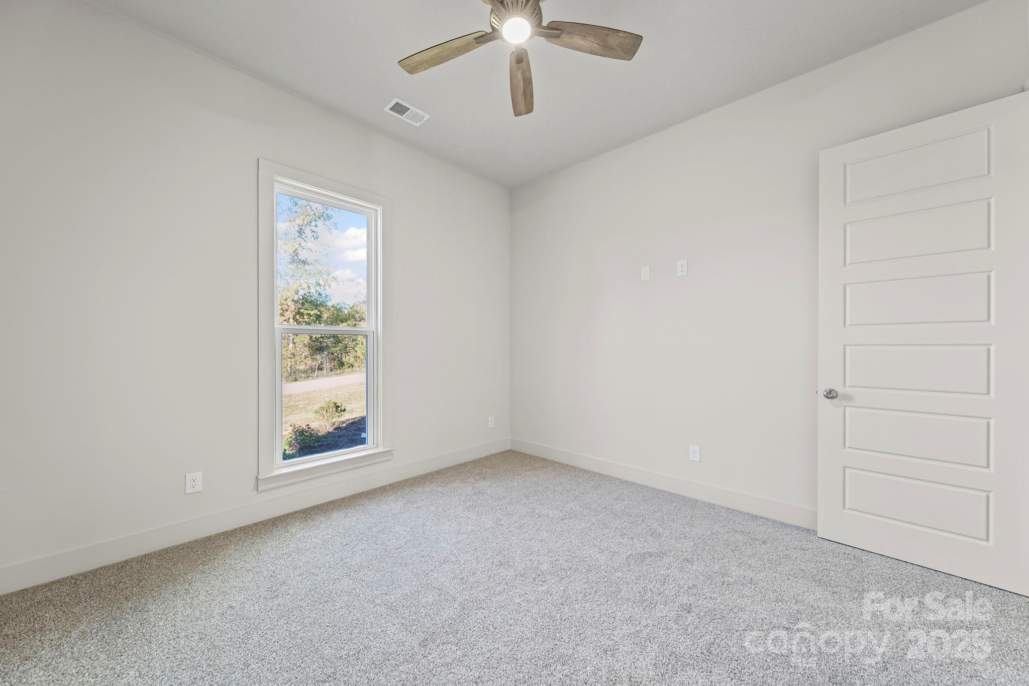 2417 Plyler Mill Road Monroe, NC 28112 - Photo 20 of 34 an empty room with windows and ceiling fan