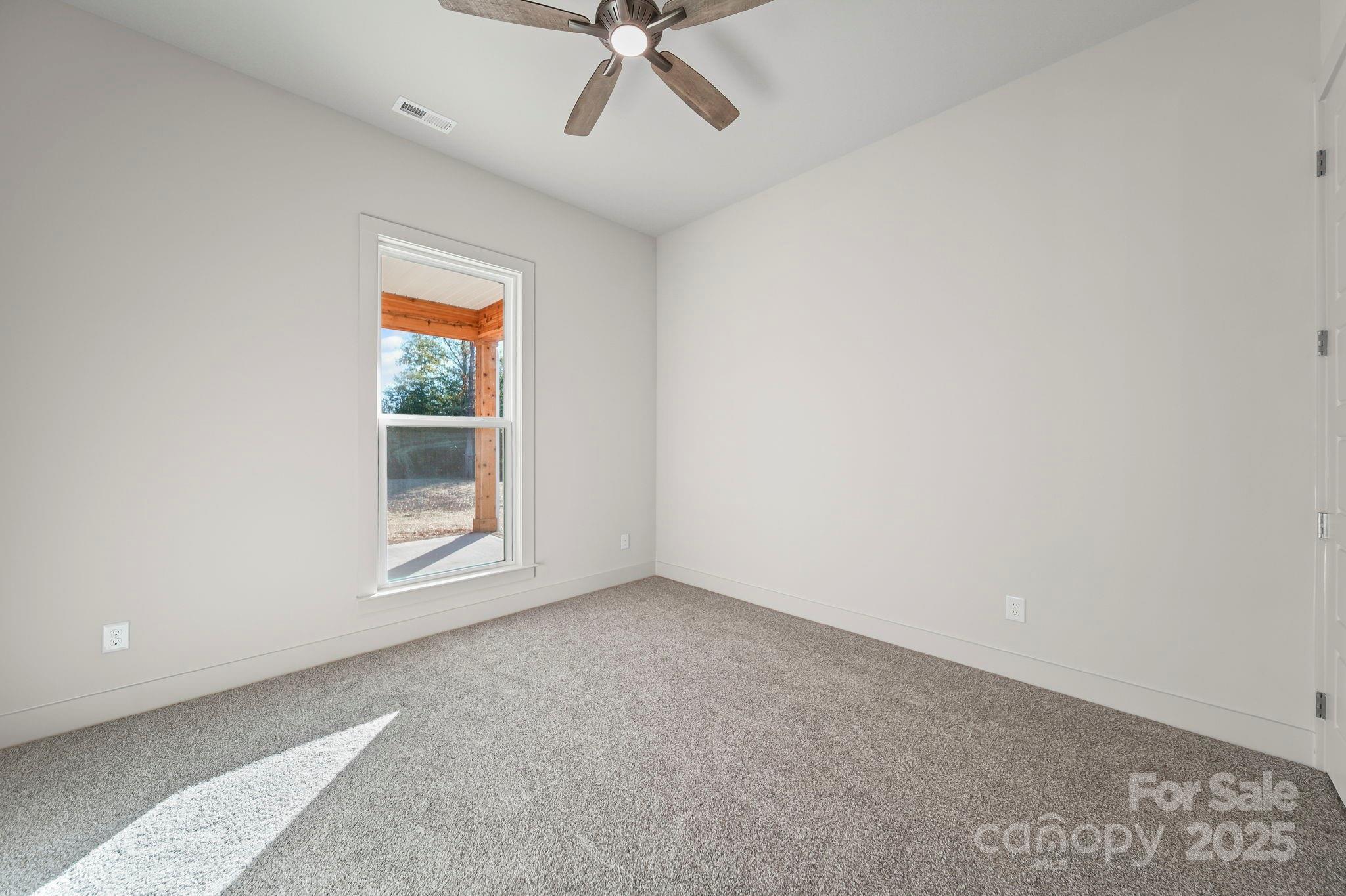 2417 Plyler Mill Road Monroe, NC 28112 - Photo 22 of 34 an empty room with a ceiling fan and windows