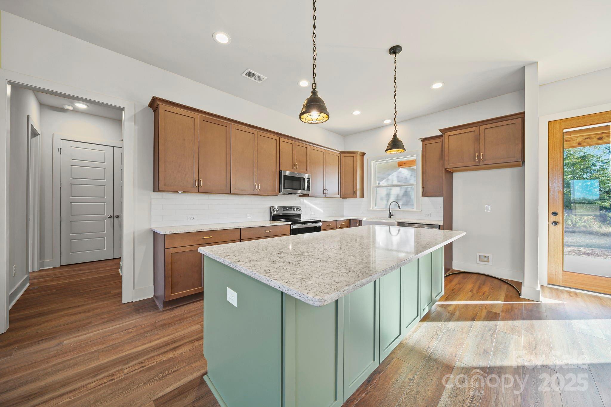 2417 Plyler Mill Road Monroe, NC 28112 - Photo 29 of 34 a kitchen with stainless steel appliances granite countertop a sink dishwasher a refrigerator and a stove with wooden floor