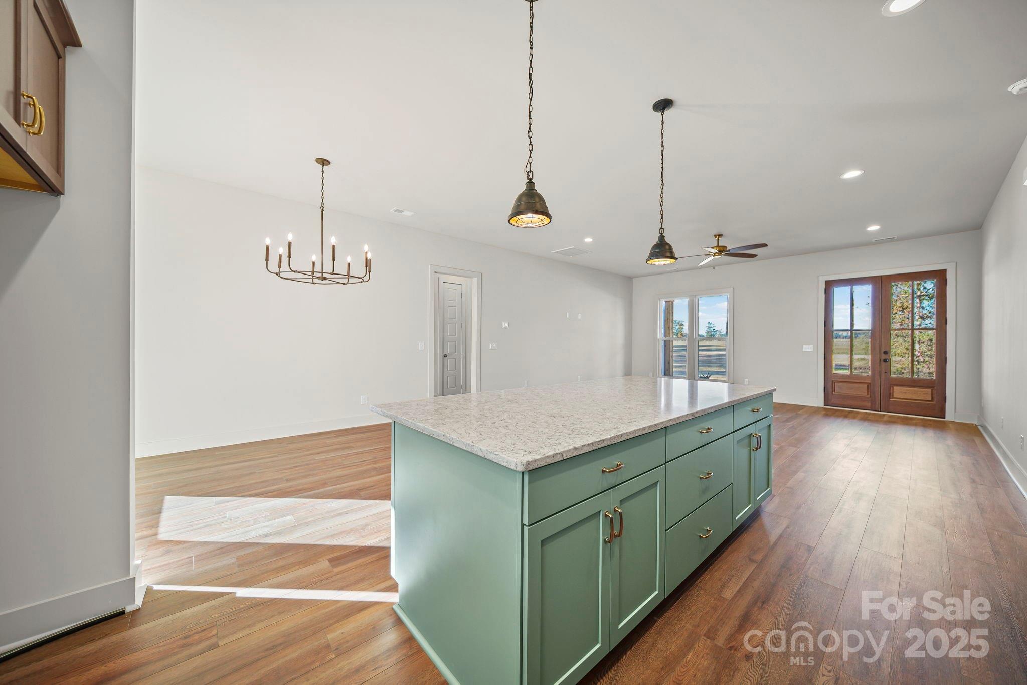 2417 Plyler Mill Road Monroe, NC 28112 - Photo 3 of 34 a kitchen with kitchen island white cabinets and wooden floor