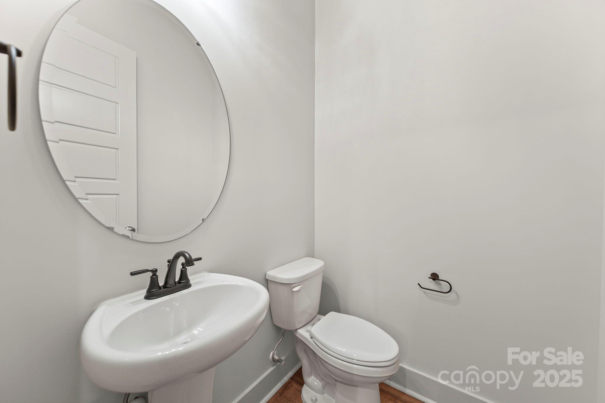 2417 Plyler Mill Road Monroe, NC 28112 - Photo 31 of 34 a bathroom with a sink a mirror and a toilet