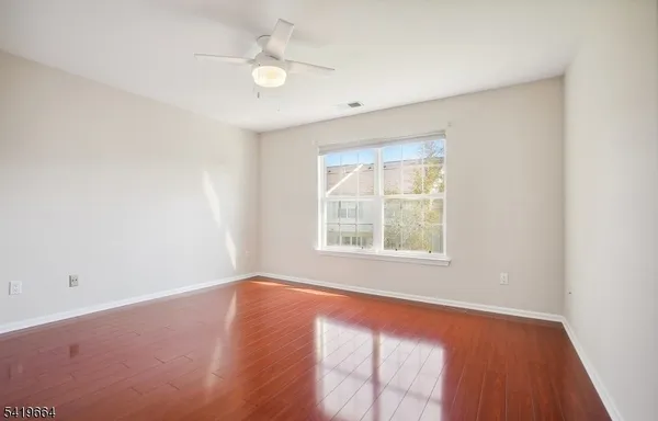 an empty room with a window and a fan
