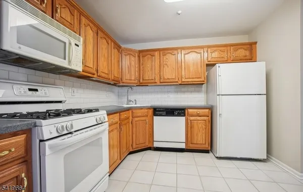 a kitchen with stainless steel appliances granite countertop a refrigerator a stove a sink and dishwasher
