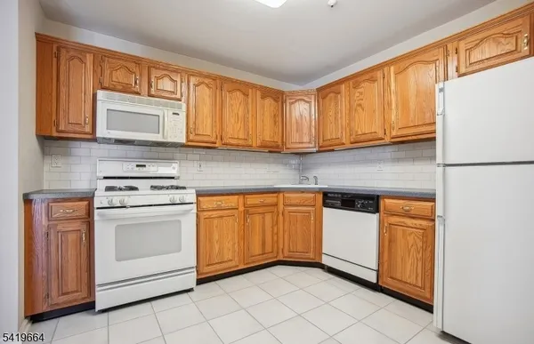 a kitchen with granite countertop cabinets stainless steel appliances and a sink