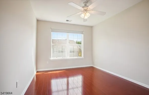 an empty room with a window and a fan