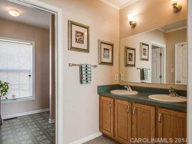 6713 Potter Road Waxhaw, NC 28173 - Photo 12 of 16 a bathroom with a granite countertop sink a mirror and a shower