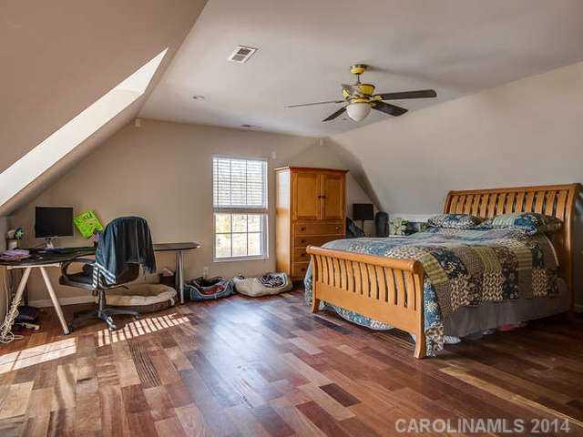6713 Potter Road Waxhaw, NC 28173 - Photo 13 of 16 a bedroom with a bed a chandelier and a dresser