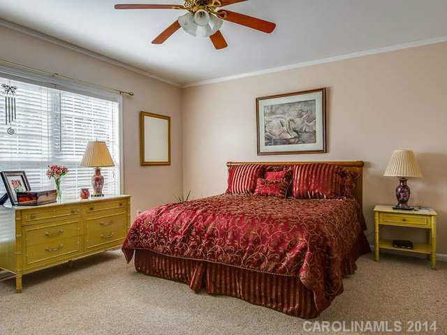 6713 Potter Road Waxhaw, NC 28173 - Photo 8 of 16 a bedroom with a bed and a chandelier