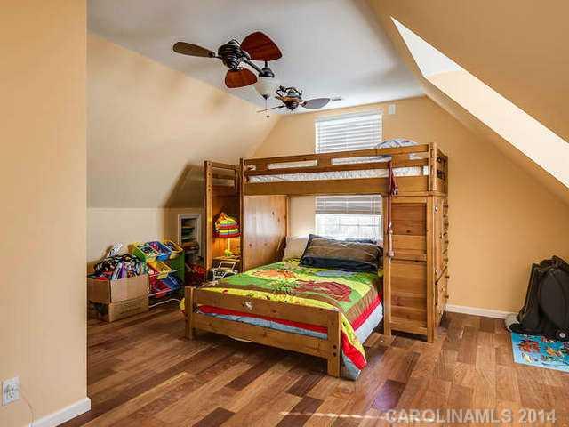 6713 Potter Road Waxhaw, NC 28173 - Photo 10 of 16 a bedroom with a bed and a chandelier