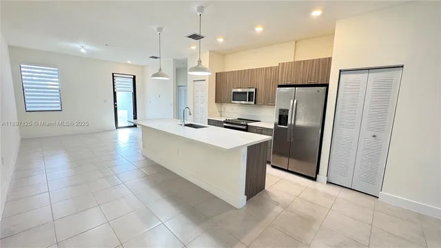 a kitchen with stainless steel appliances granite countertop a refrigerator and a sink