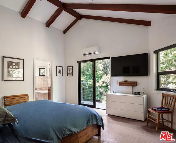 a bedroom with a bed and a flat screen tv