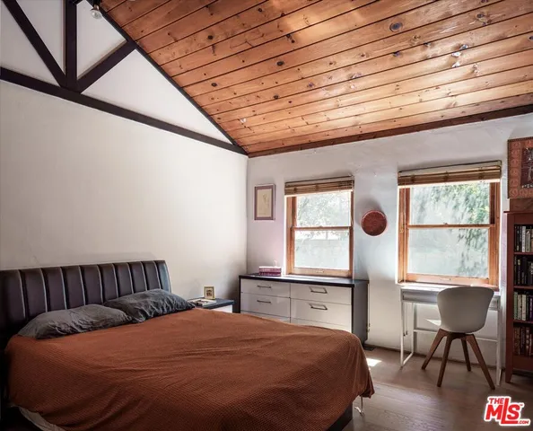 a bedroom with a bed window and table