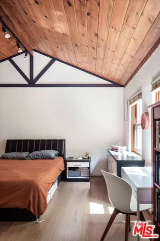 a bedroom with a bed a table and chair