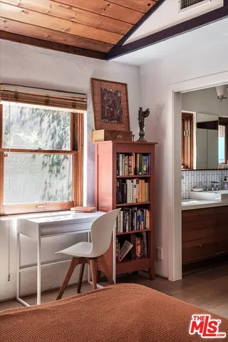 a view of a workspace with furniture and a window