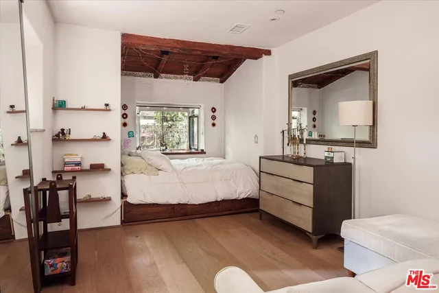 a spacious bedroom with a bed and wooden floor