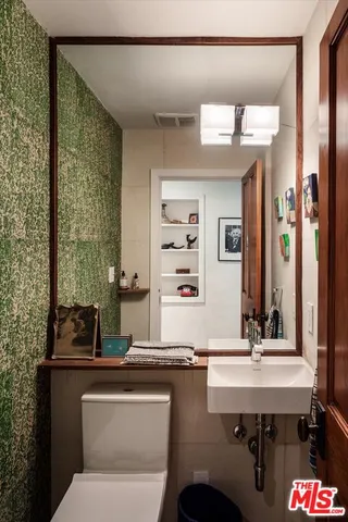 a bathroom with a sink a toilet and mirror