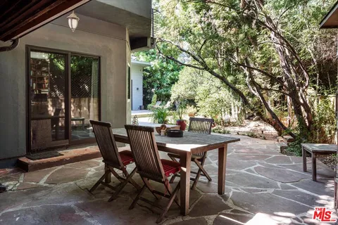 a view of a patio with table and chairs and potted plants