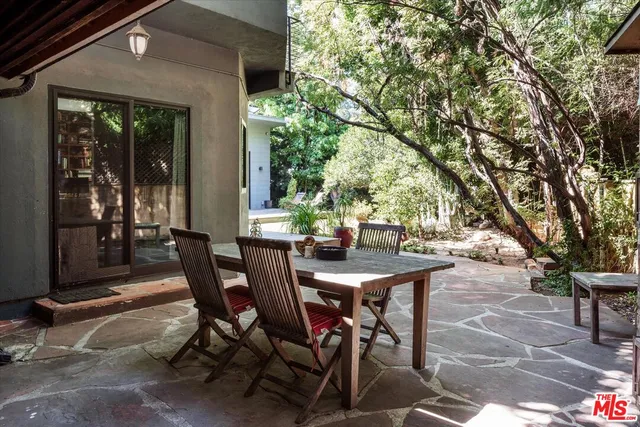 a view of a patio with table and chairs and potted plants