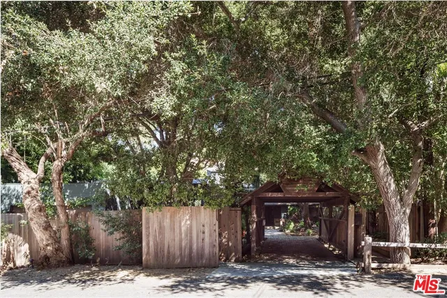 a front view of a house with a tree