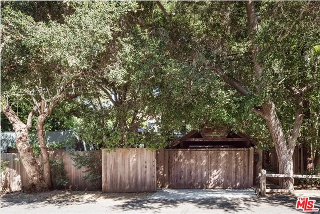 a view of a barn with large trees