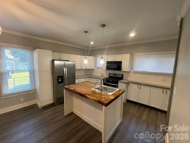 a kitchen with granite countertop a sink stove and refrigerator