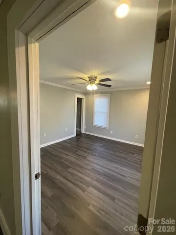 a view of empty room with wooden floor