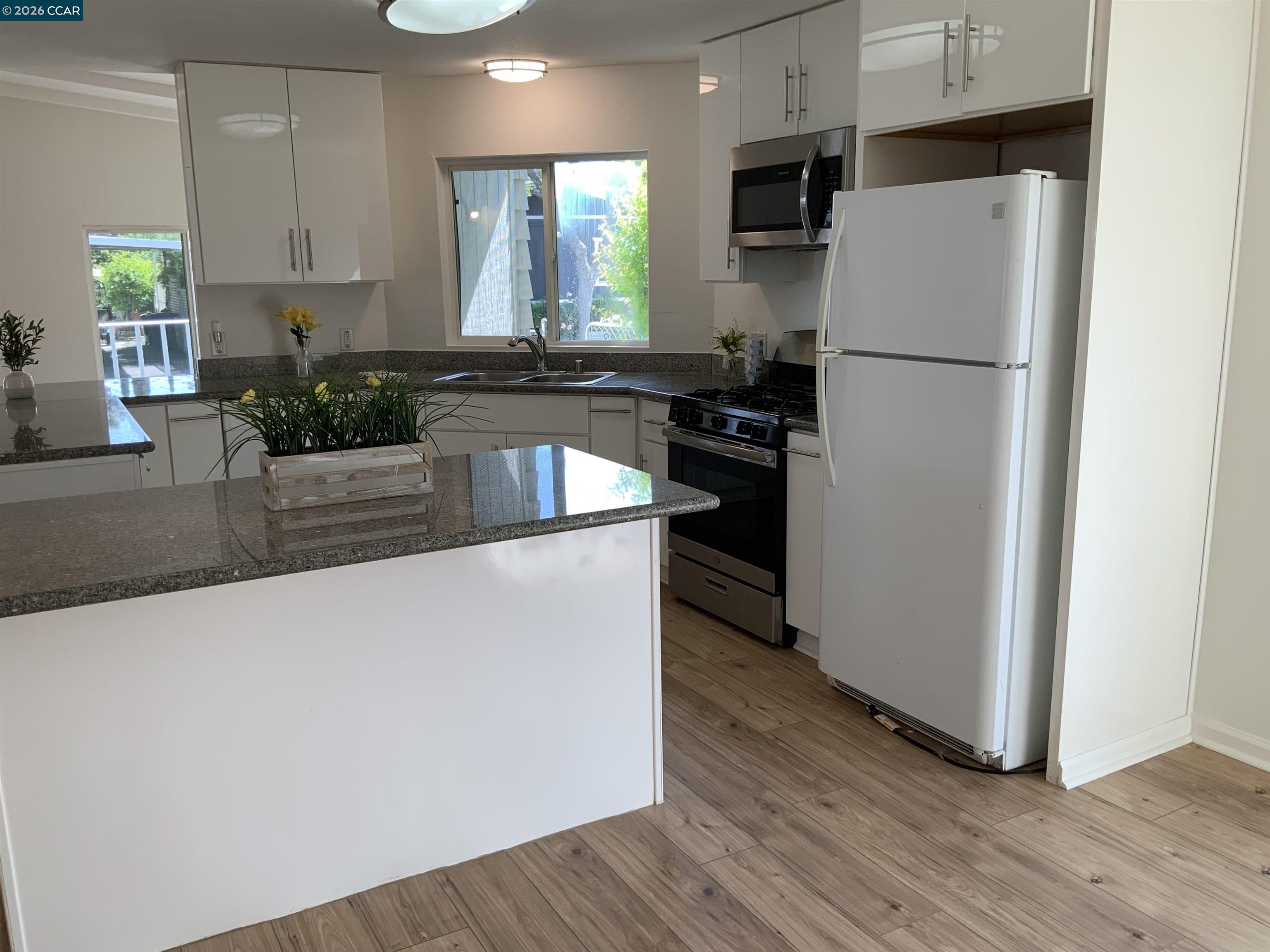 140 Shannon Pittsburg, CA 94565 - Photo 13 of 37 a kitchen with granite countertop a refrigerator and a stove top oven