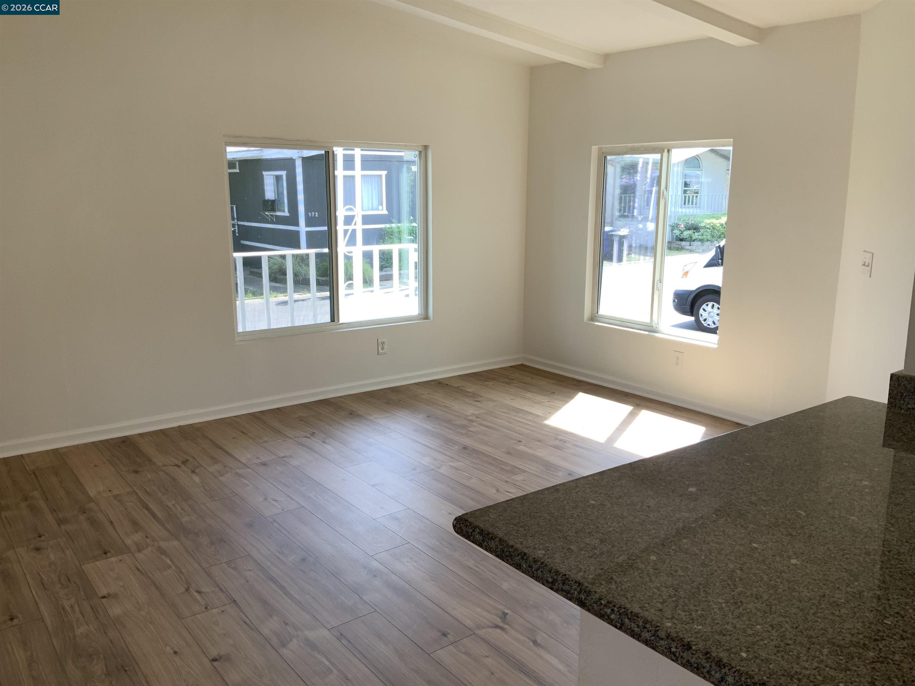 140 Shannon Pittsburg, CA 94565 - Photo 8 of 37 an empty room with wooden floor and windows