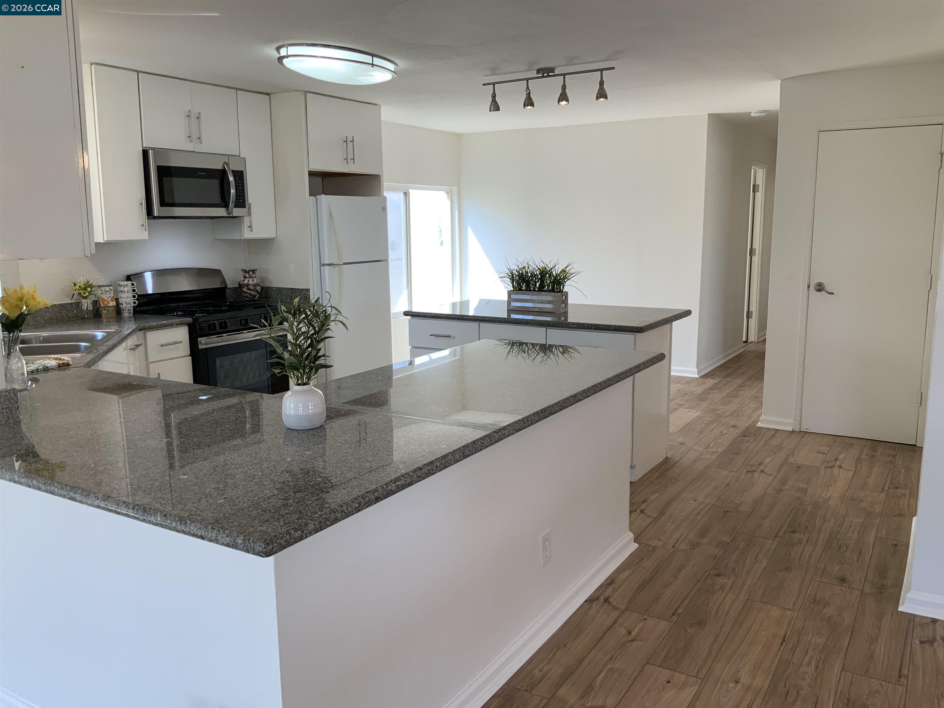 140 Shannon Pittsburg, CA 94565 - Photo 10 of 37 a kitchen with stainless steel appliances granite countertop a sink a stove and a wooden floors