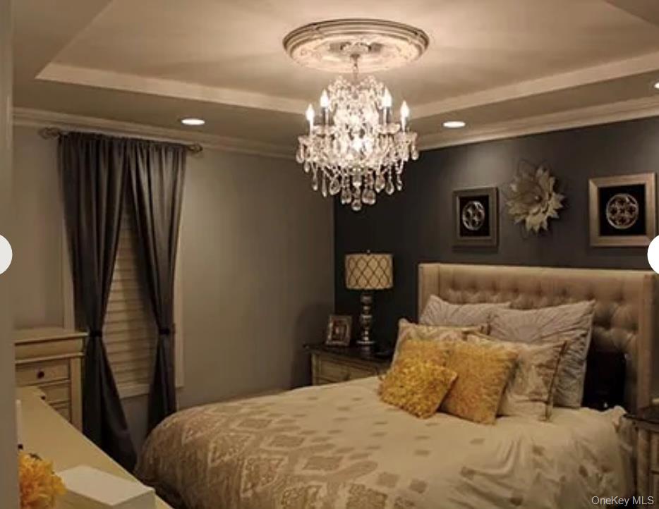 78-45 79th Place Queens, NY 11385 - Photo 16 of 36 a bedroom with a large bed and a chandelier