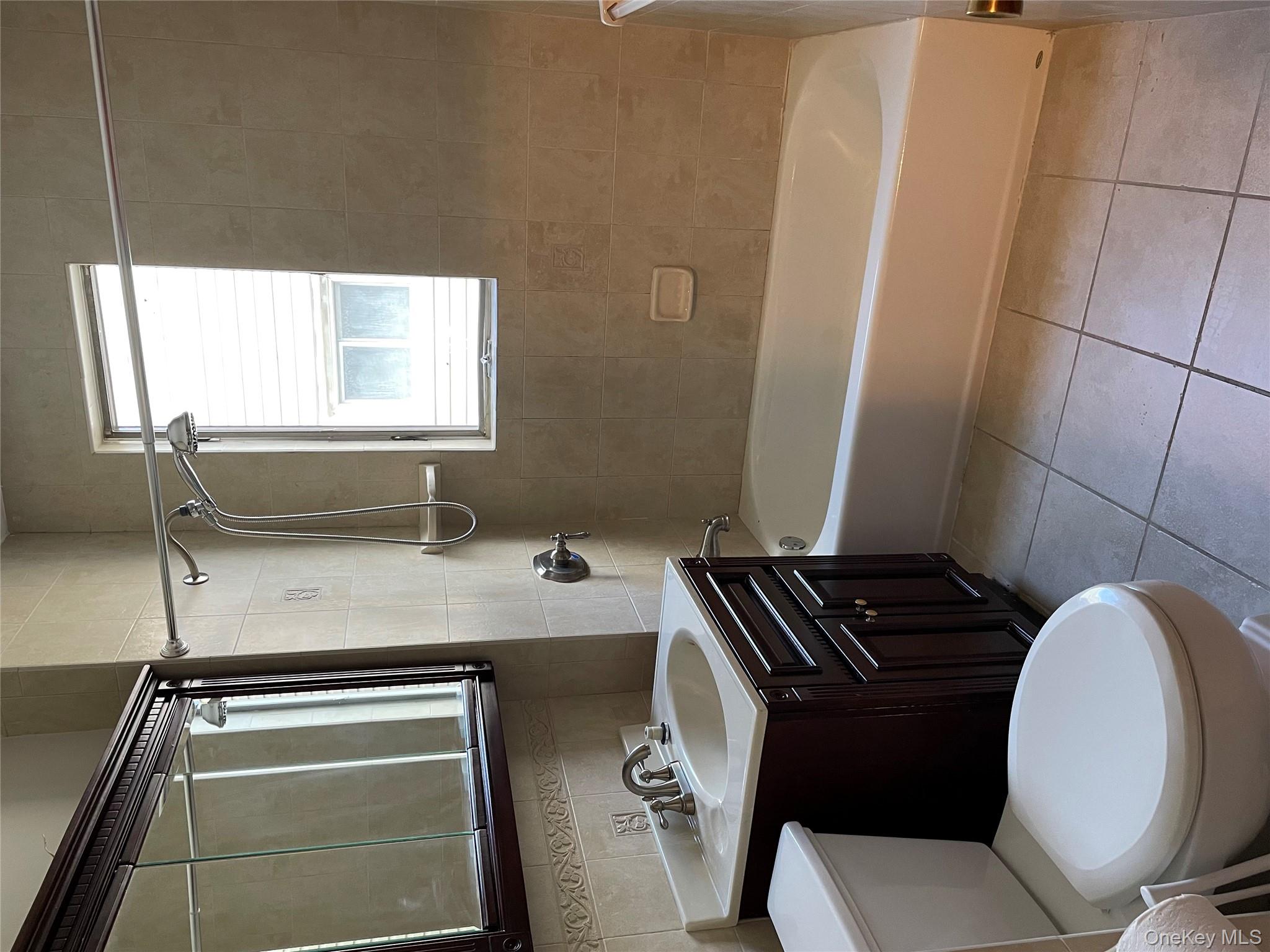 78-45 79th Place Queens, NY 11385 - Photo 17 of 36 a bathroom with a sink a toilet and shower