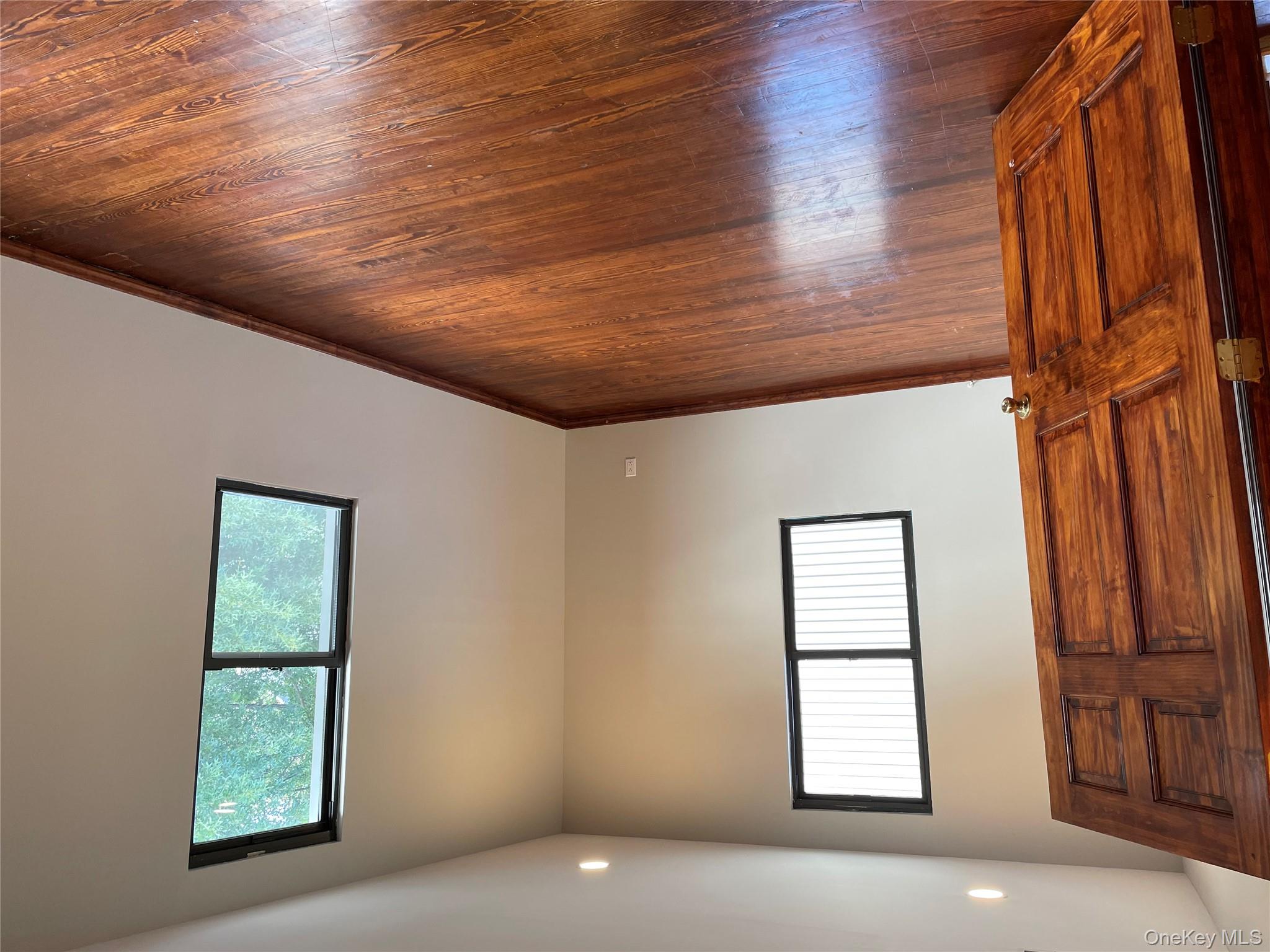 78-45 79th Place Queens, NY 11385 - Photo 18 of 36 an empty room with wooden floor and windows