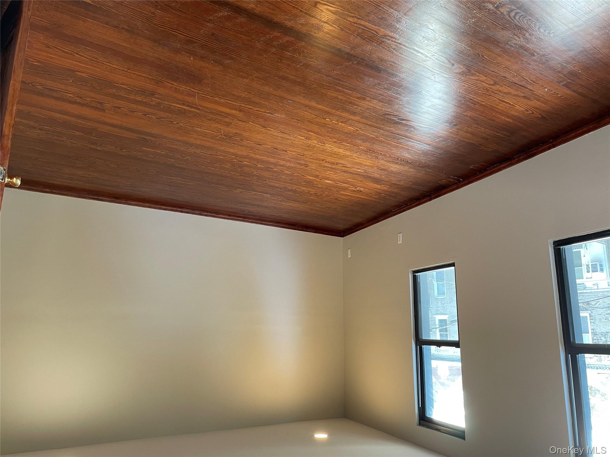 78-45 79th Place Queens, NY 11385 - Photo 19 of 36 an empty room with wooden floor and windows