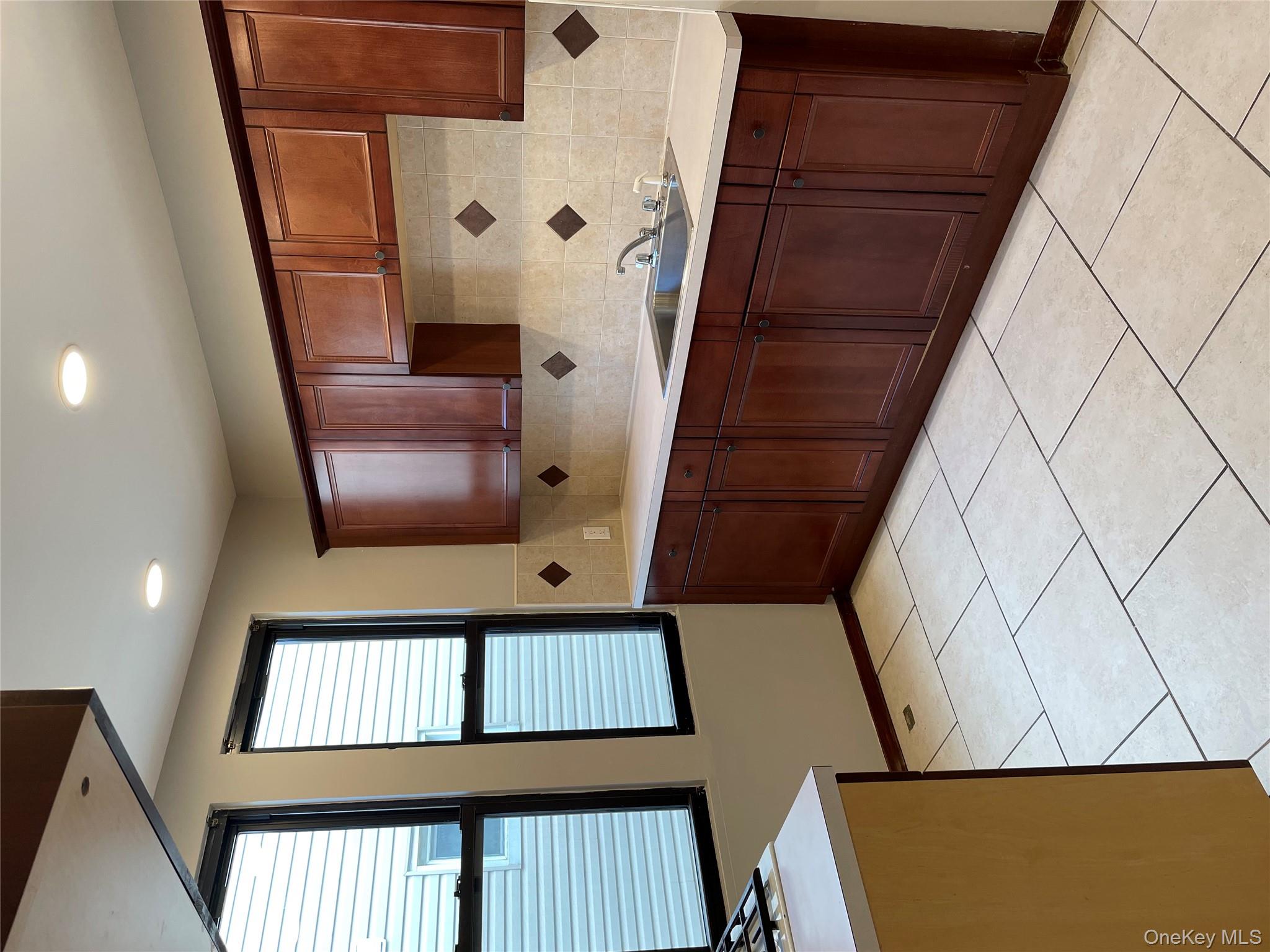 78-45 79th Place Queens, NY 11385 - Photo 20 of 36 a kitchen with a sink and wooden cabinets
