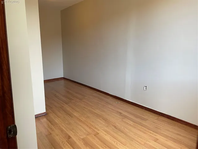 a view of an empty room and wooden floor