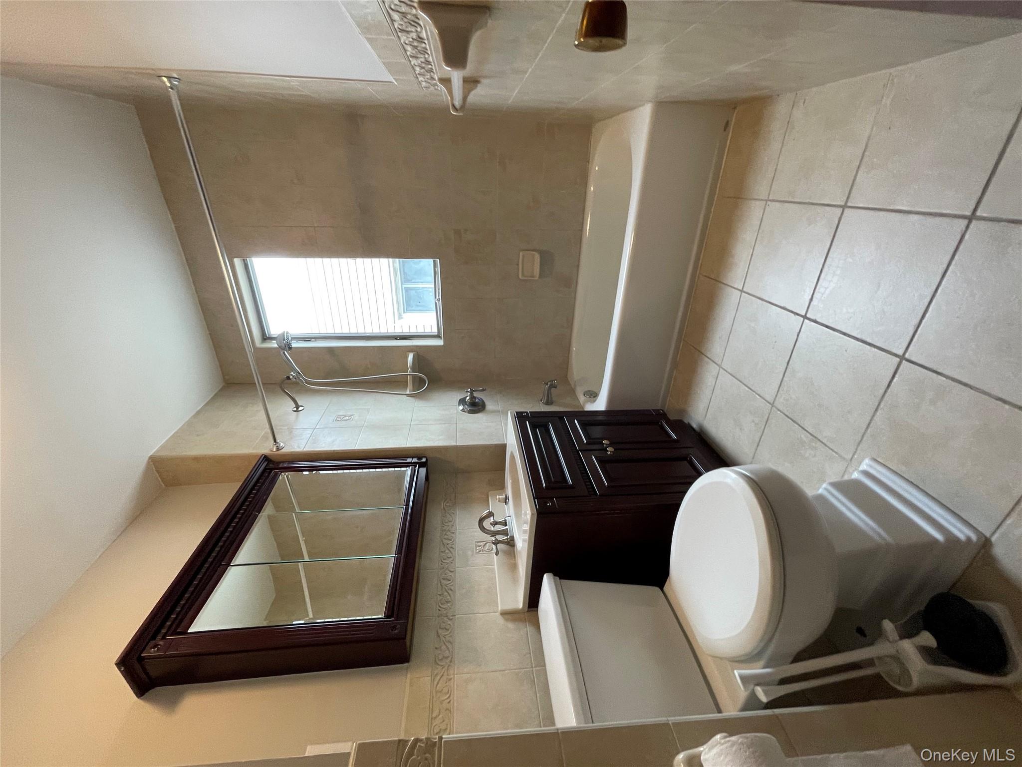 78-45 79th Place Queens, NY 11385 - Photo 34 of 36 a bathroom with a toilet a sink and a bathtub