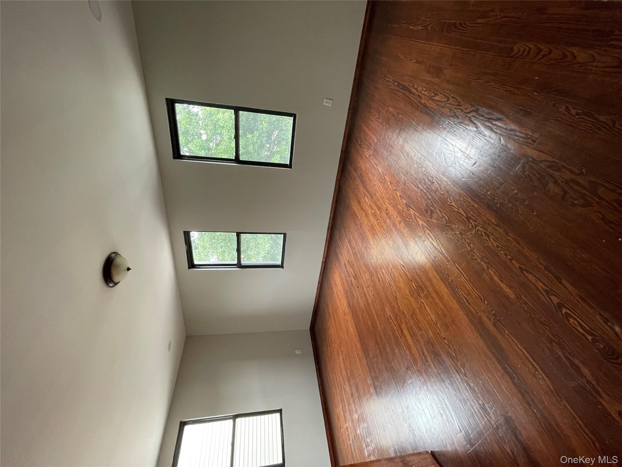 78-45 79th Place Queens, NY 11385 - Photo 35 of 36 an empty room with wooden floor and windows