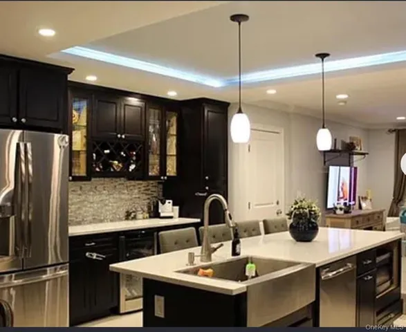 a kitchen with a sink refrigerator and chairs
