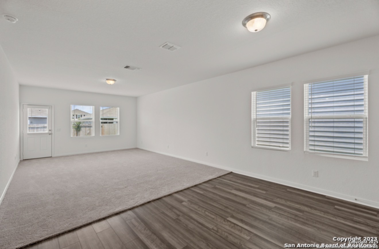 14677 Maple Terrace San Antonio, TX 78253 - Photo 11 of 13 an empty room with wooden floor and windows