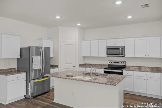 a kitchen with stainless steel appliances granite countertop a refrigerator sink and stove