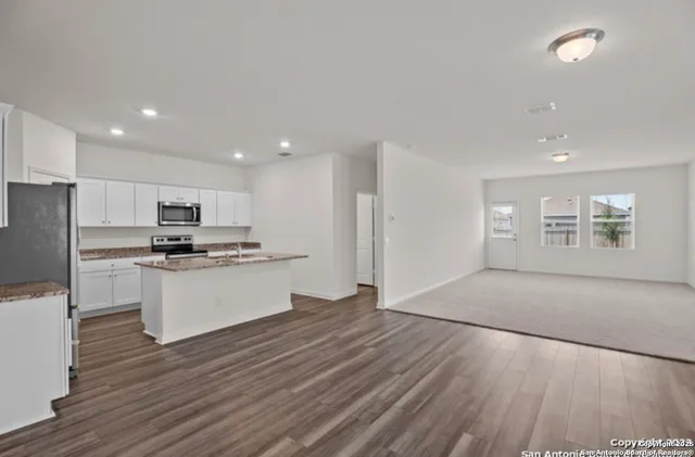 a kitchen with a refrigerator and a stove top oven