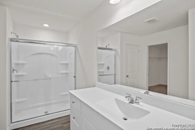 a bathroom with a shower sink vanity and a mirror