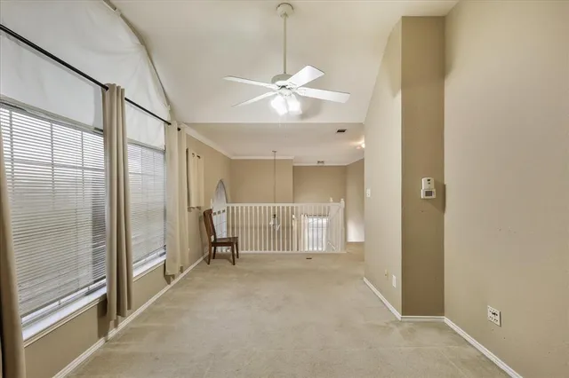 a view of a livingroom with a chandelier fan and windows