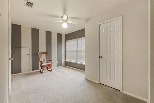 a view of a bedroom with a furniture and a ceiling fan