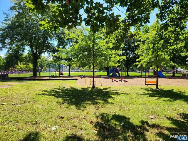 a view of a house with a big yard and palm trees