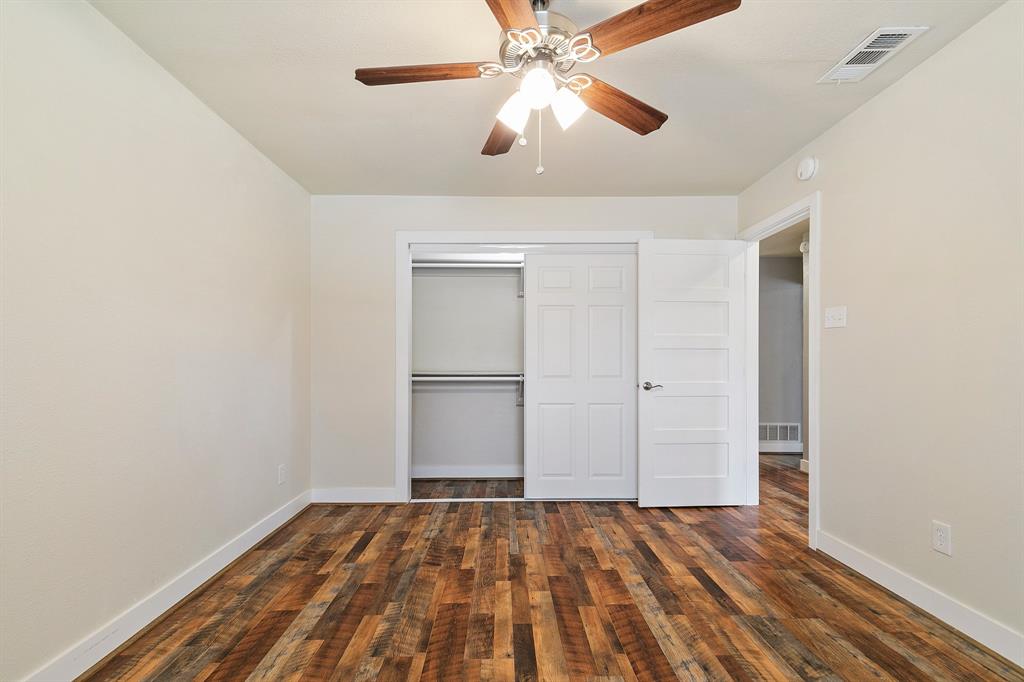 909 North Dove Road Grapevine, TX 76051 - Photo 24 of 30 3rd bedroom featuring wood-finish flooring, a ceiling fan with light fixture, and a closet with bifold doors