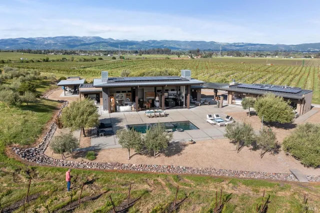 an aerial view of a house with lake view and a floor to ceiling window