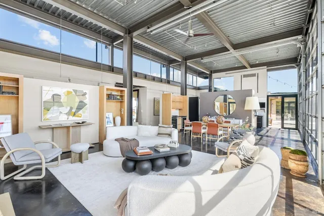 a bedroom with a bed and large windows