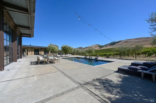 a bedroom with a bed wooden floor and view of living room